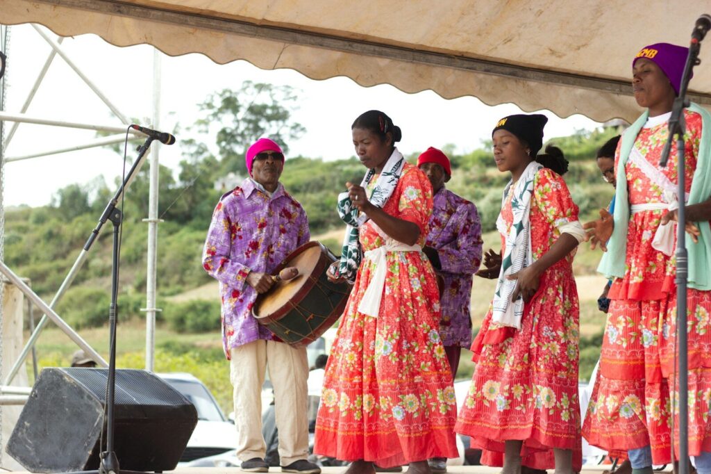 People in colorful traditional clothing performing on stage.